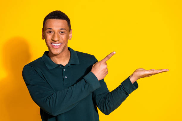 istock Photo of nice young man direct finger hold empty space wear pullover isolated on bright yellow color background 2172573484