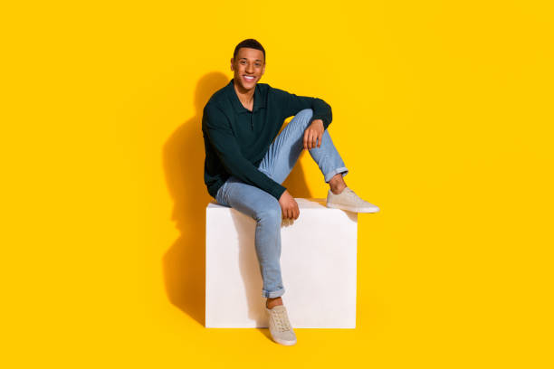 istock Full size photo of handsome young guy sit white cube relaxed dressed stylish green garment isolated on yellow color background 2172573717