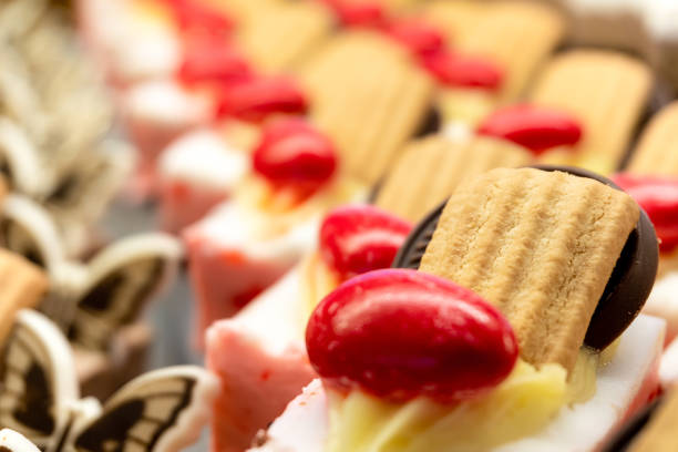 Savoiardi cakes decorated with chocolate pieces and glazed nuts in a restaurant. Creative photo. Selective focus. Close-up view.