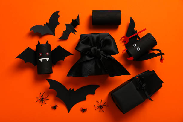 istock Gift boxes and paper bats on orange background, top view 2172576665