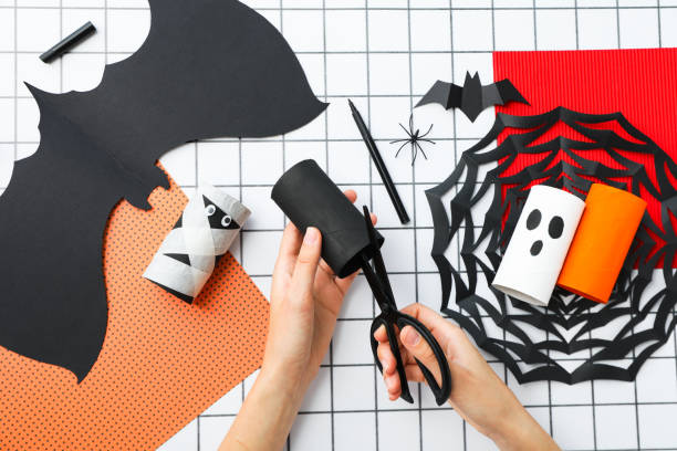 istock Paper Halloween mockups and scissors in female hands on light background, top view 2172576720