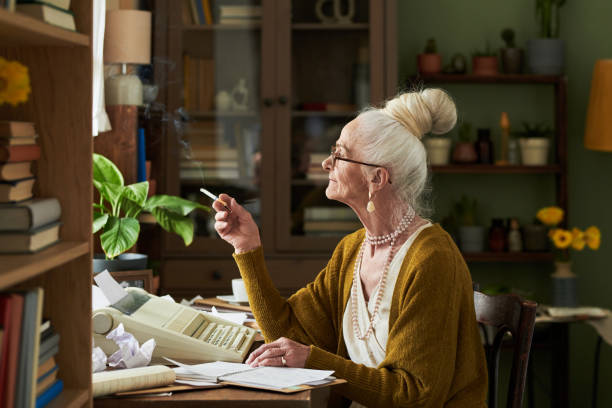 istock Elderly Woman Smoking Cigarette While Working at Desk 2172580794