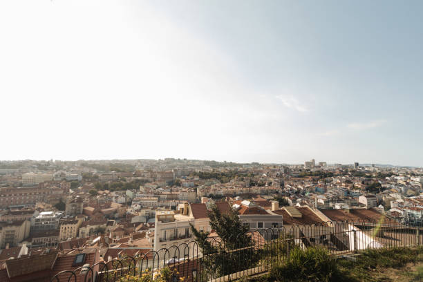 A wide-angle view of Lisbon's sprawling cityscape, showcasing the rooftops and distant hills under a clear, sunny sky. The perfect representation of the city's urban beauty and charm.