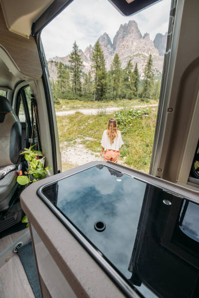istock Woman Relaxing Outside Campervan with Mountain View 2172583261