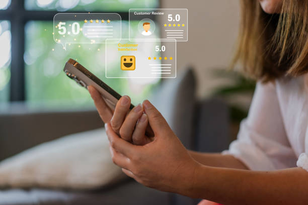 istock Customer satisfaction feedback with five star rating system, hand hold smartphone with digital smiley face quality service review, business evaluation, client experience, online review management 2172583359