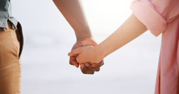 istock Outdoor, people and couple holding hands for bonding, support and unity on break. Outside, relationship and closeup of lovers on holiday or vacation to relax, chill and adventure for trust and care 2172584922