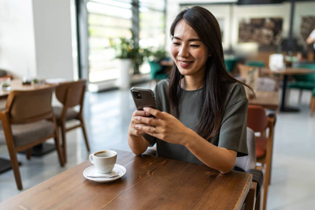 istock Asian woman using smart phone in the coffee shop 2172587342