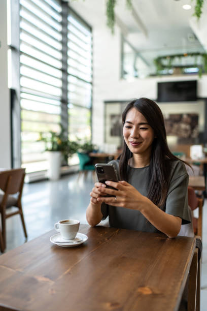 istock Asian woman using smart phone in the coffee shop 2172587934