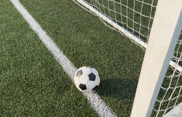 istock Soccer ball in goal on blue background 2172588950