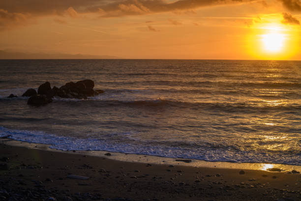 istock sunset on the sea - A sea wave breaks on a large stone with beautiful white splashes. 2172589079