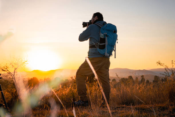 istock photographer, alone and contemplative. With camera in hand and backpack on his back, adventurer concept, local travel 2172589683