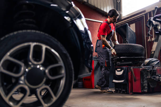 istock Hardworking mechanic removing damaged tire from the wheel inside workshop. 2172594332