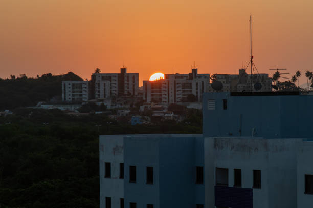 Late afternoon sun setting behind residential buildings.