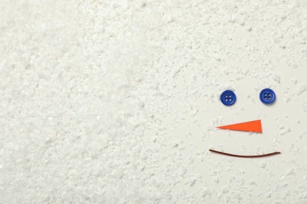 Snowman face with paper carrot and buttons