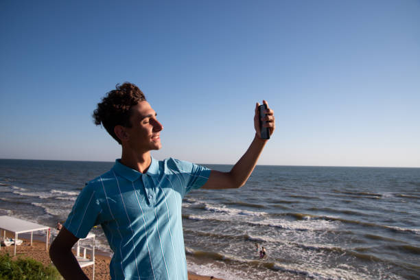 istock A young attractive guy is walking on the beach. 2172601212