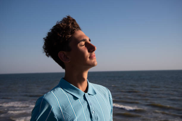 istock A young attractive guy is walking on the beach. 2172601878