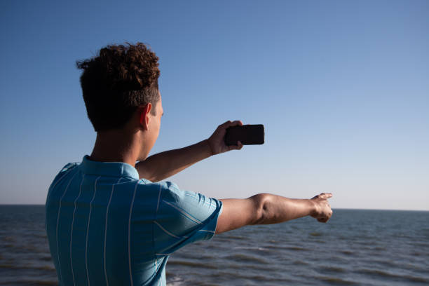 istock A young attractive guy is walking on the beach. 2172602464