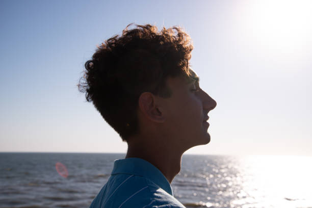 istock A young attractive guy is walking on the beach. 2172602544