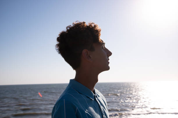 istock A young attractive guy is walking on the beach. 2172602579