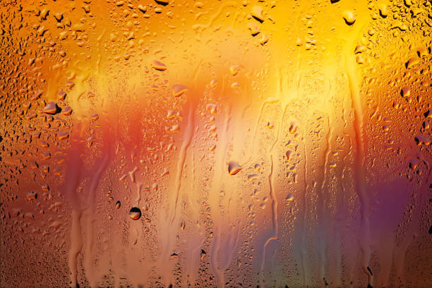 Drops of rain on the window. Water drops on glass. Abstract background. Multi-colored spots. Drops texture. Soft focus
