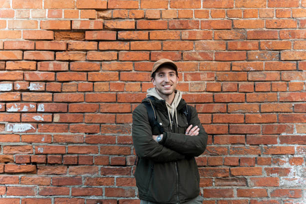 istock Portrait of a smiling man leaning on brick wall 2172607541