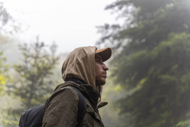 Man hiking in the forest on a cool rainy autumn day. Concept of sport in nature