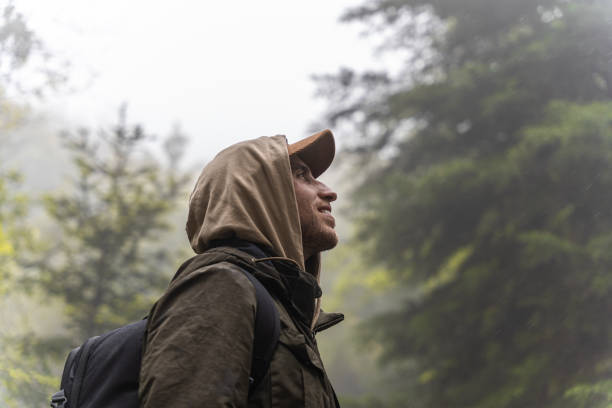 Man hiking in the forest on a cool rainy autumn day. Concept of sport in nature