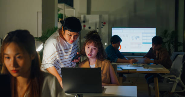 istock Colleagues engage in a focused business discussion over a laptop in an office, indicative of a collaborative late-night work session. ESG sustainable business office night. 2172612708