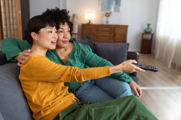 istock Lesbian couple watching TV at home 2172620480