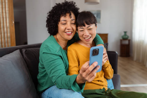 istock Diverse lesbian couple relaxing at home and using phone 2172620518