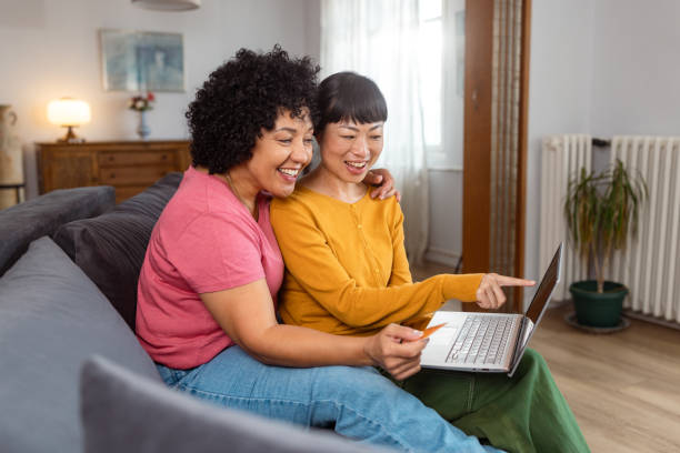 istock Happy lesbian couple using laptop together at home 2172620544