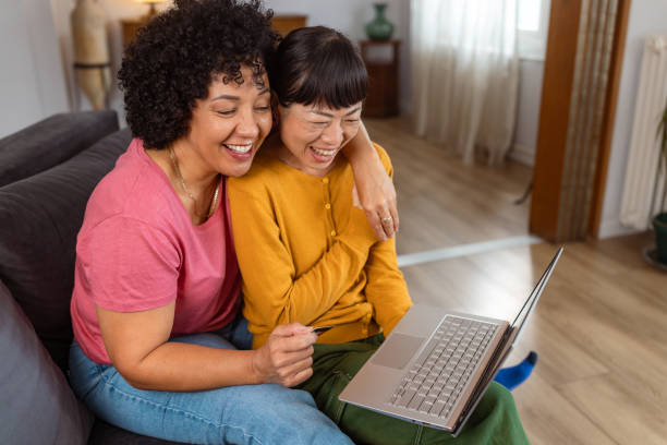 istock Happy lesbian couple using laptop together at home 2172620551