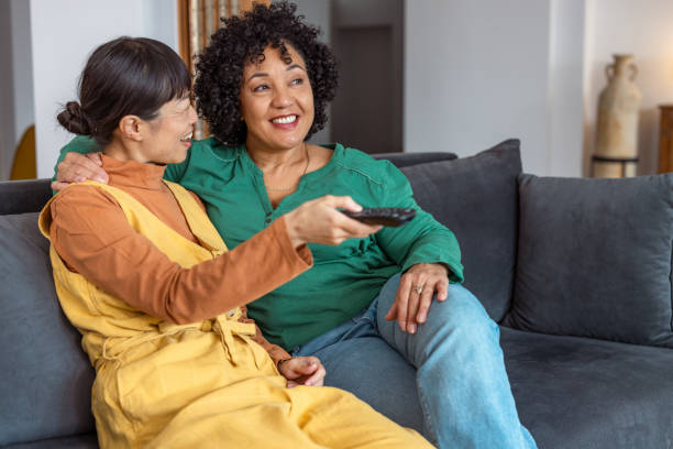 istock Lesbian couple relaxing on the couch watching television 2172620730