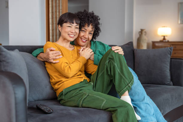 istock Happy lesbian couple embracing on cozy sofa at home 2172620741