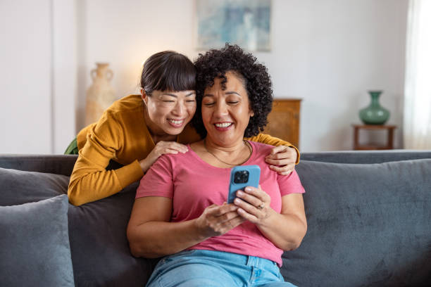 istock Two loving mature women using phone at home 2172620856
