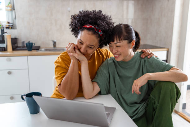 istock A lesbian couple looking at the laptop and sharing affectionate touches 2172621122