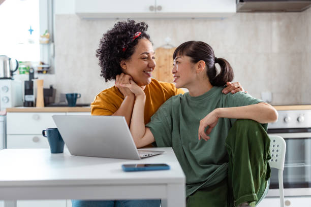 istock Photo of two lesbians cuddling while using a laptop at home 2172621272