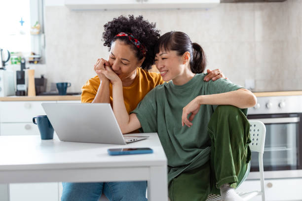 istock Happy lesbian couple using laptop together at home 2172621273