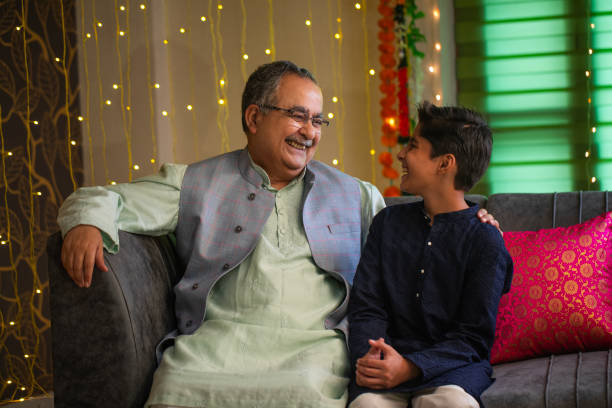 istock Grandfather and grandson talking while sitting on sofa at home 2172627754