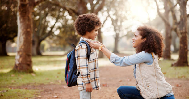 istock Love, mother and kid with backpack in forest for back to school, getting ready and fixing shirt for support in education. Family, woman and help boy in woods for morning commute and learning journey 2172631942