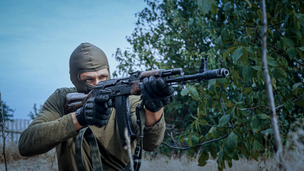 A professional military officer loads his armor and aims his machine gun