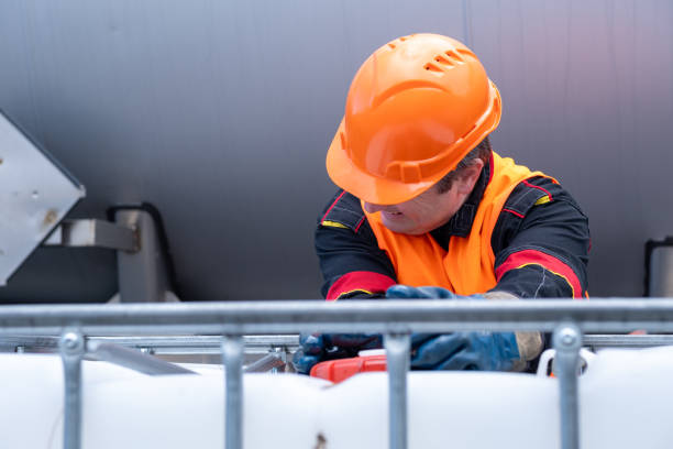 istock A technician tries hard to open the lid of a 1000-liter IBC bulk container. 2172636816