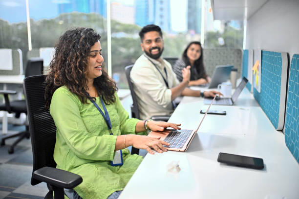 Engaged colleagues discussing while enjoying work in a modern Indian office