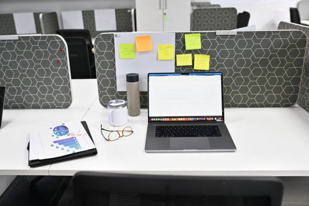 Office Desk with Open Laptop, Papers and Specs lying around