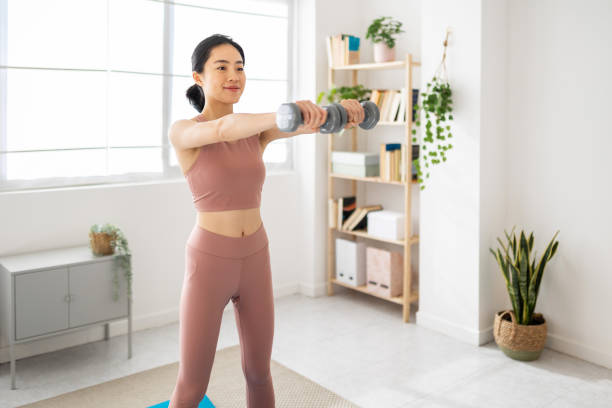 istock Young asian woman doing exercise with dumbbells at home 2172641879