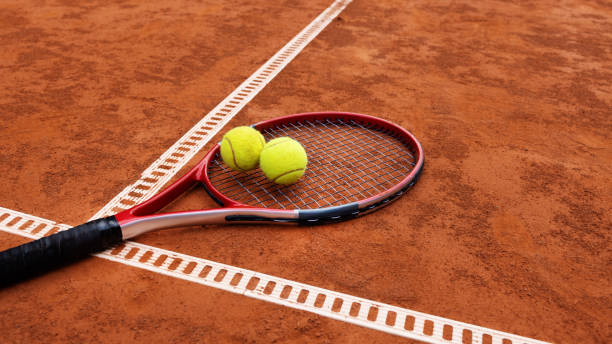 Professional female athlete serving during a tennis match on a clay court, seen from a high angle