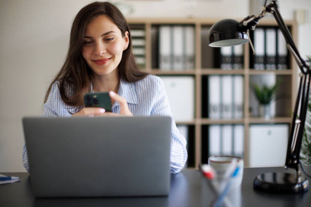 istock Smiling businesswoman using mobile phone at office 2172648252
