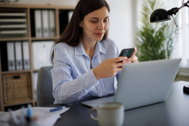 istock Smiling businesswoman using mobile phone at office 2172648255
