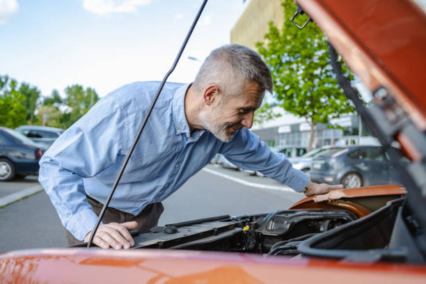 istock Mature man trying to resolve problem on his car 2172648950