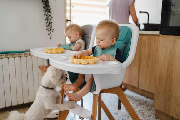 istock Twins eating vegetables while mother doing chores in kitchen 2172652817
